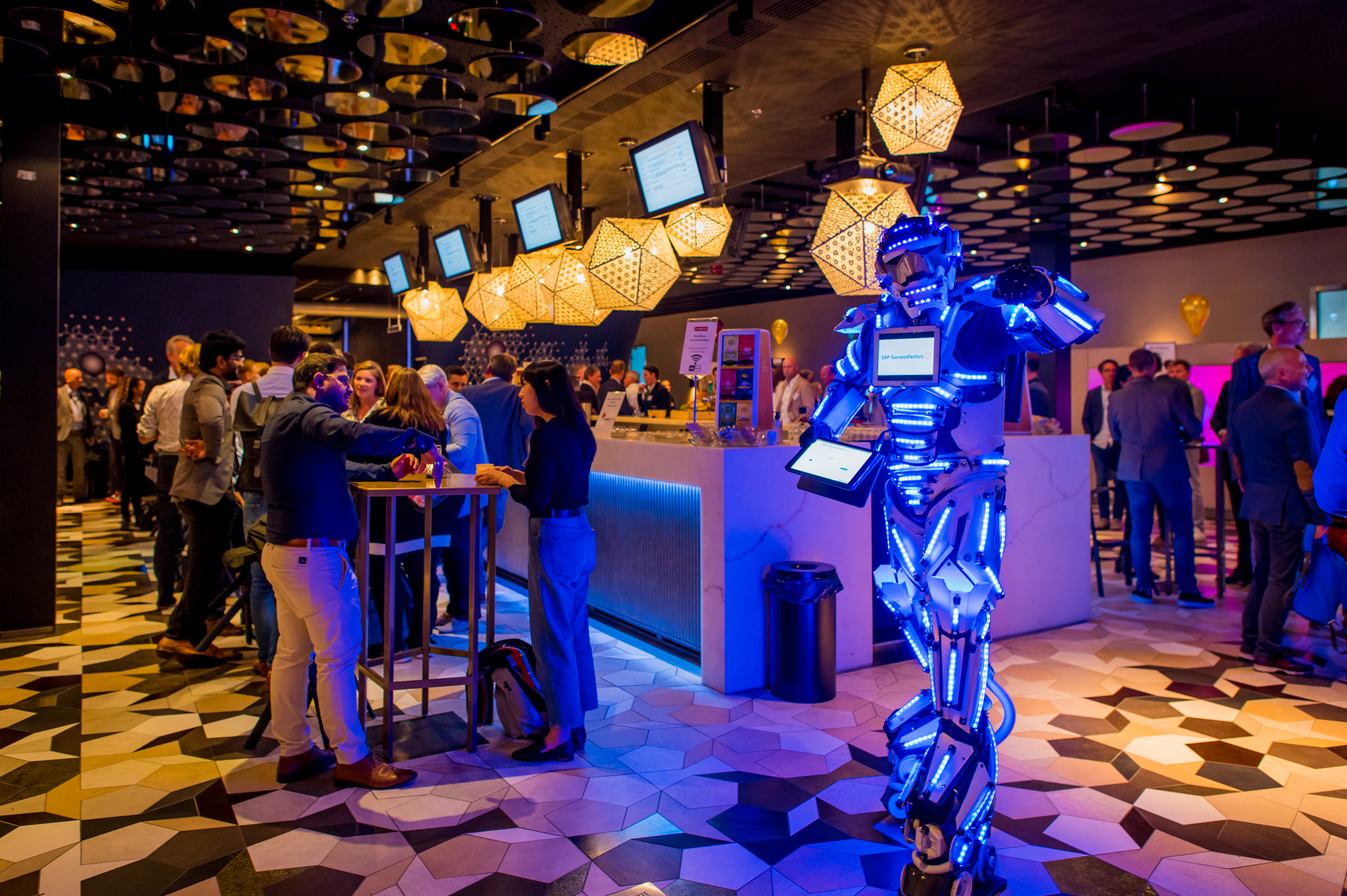 Een moderne bar omringd door sta - tafels waar mensen met elkaar netwerken.