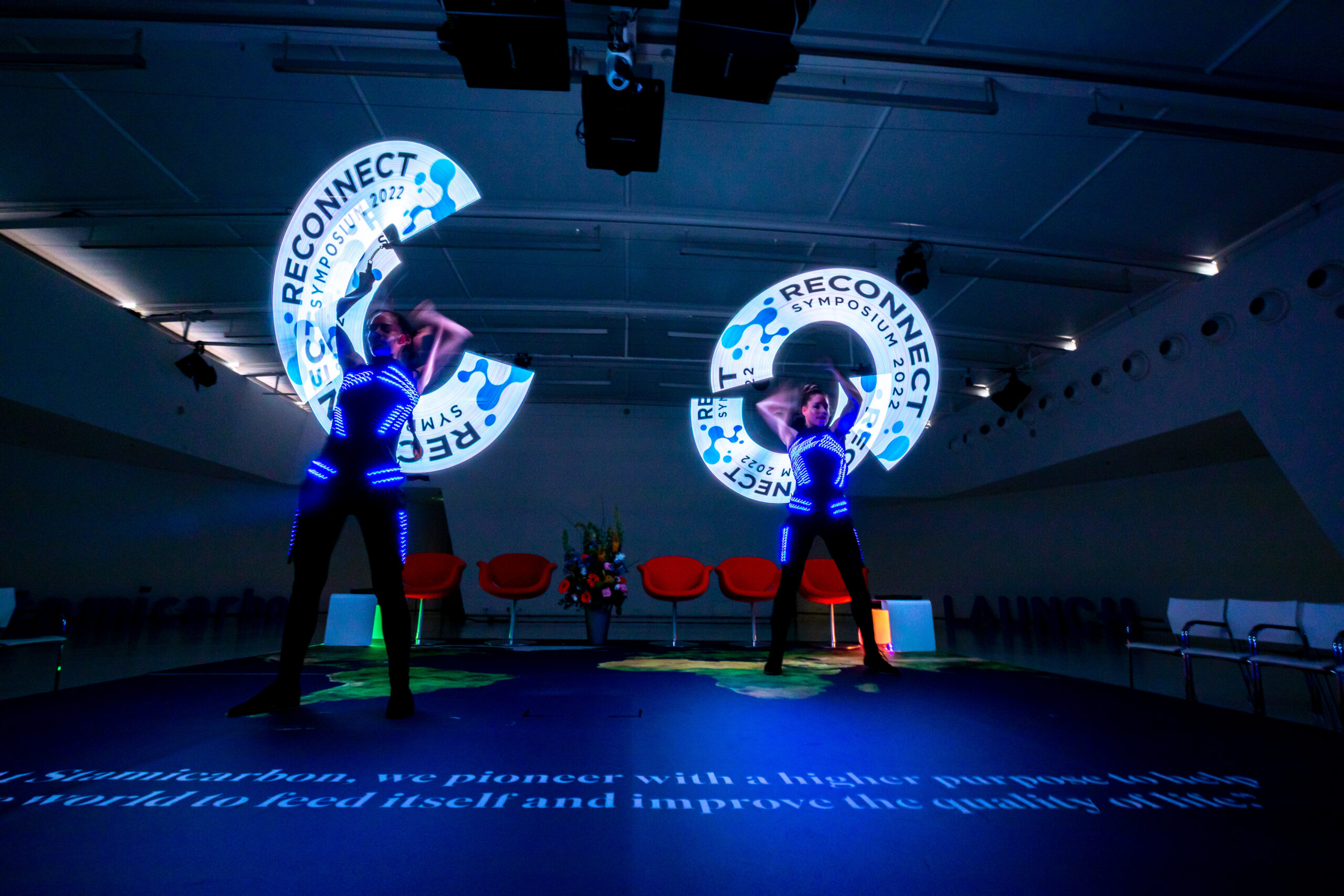 2 vrouwen dansen op podium met lichtgevende waaiers