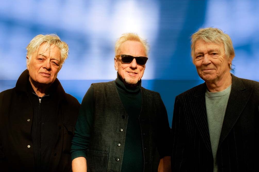 Drie mannen kijkend naar de camera