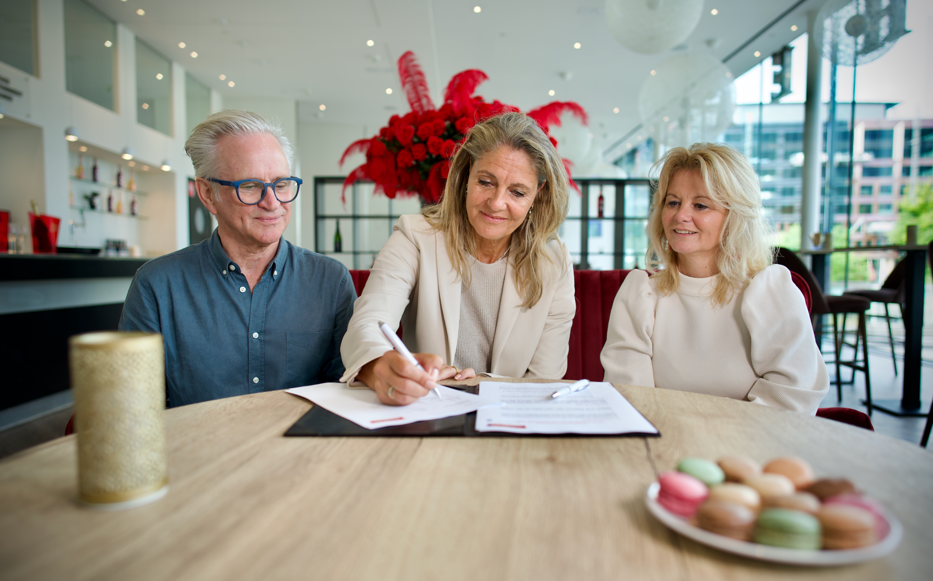 Man en twee dames op de foto zetten een handtekening