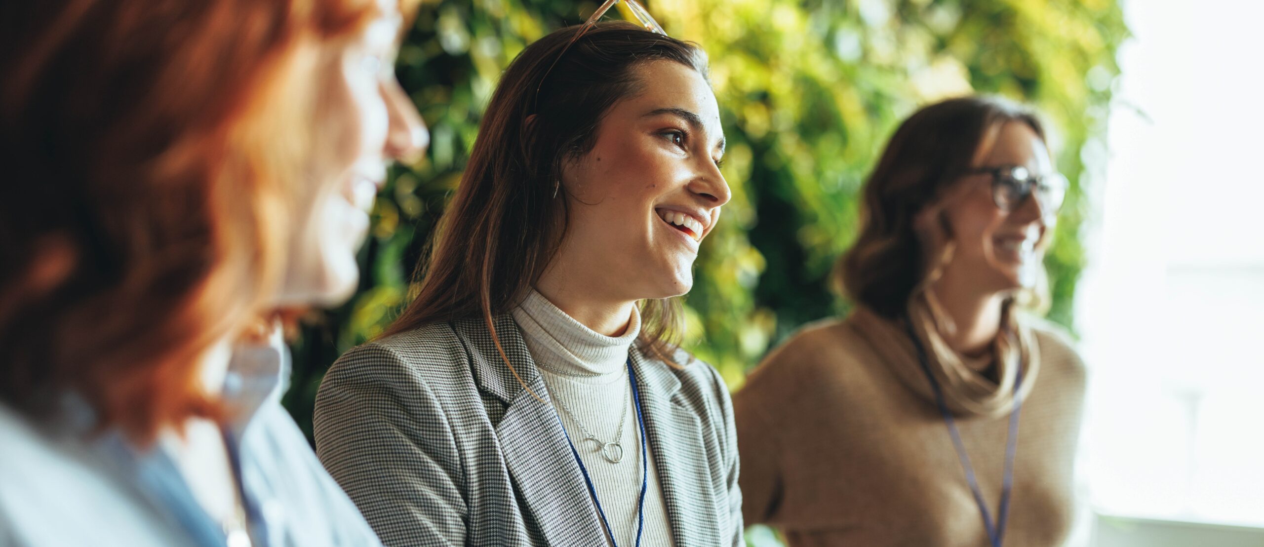 3 vrouwen lachen met groene achtergrond