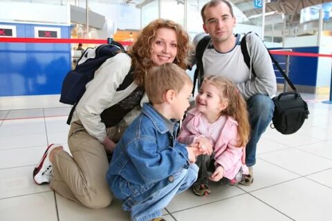 man vrouw en kinderen met reistassen