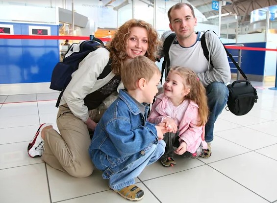 man vrouw en kinderen met reistassen