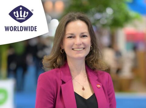 Vrouw lachend in roze jas