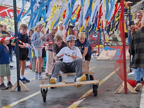 kind op skateboard tussen andere kinderen